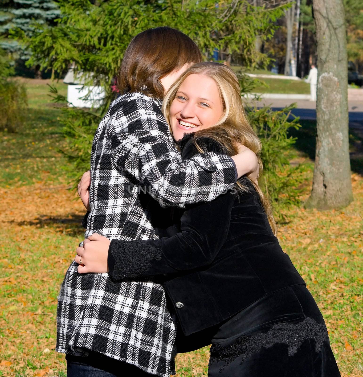 Two girls embrace at a meeting, rejoicing each other