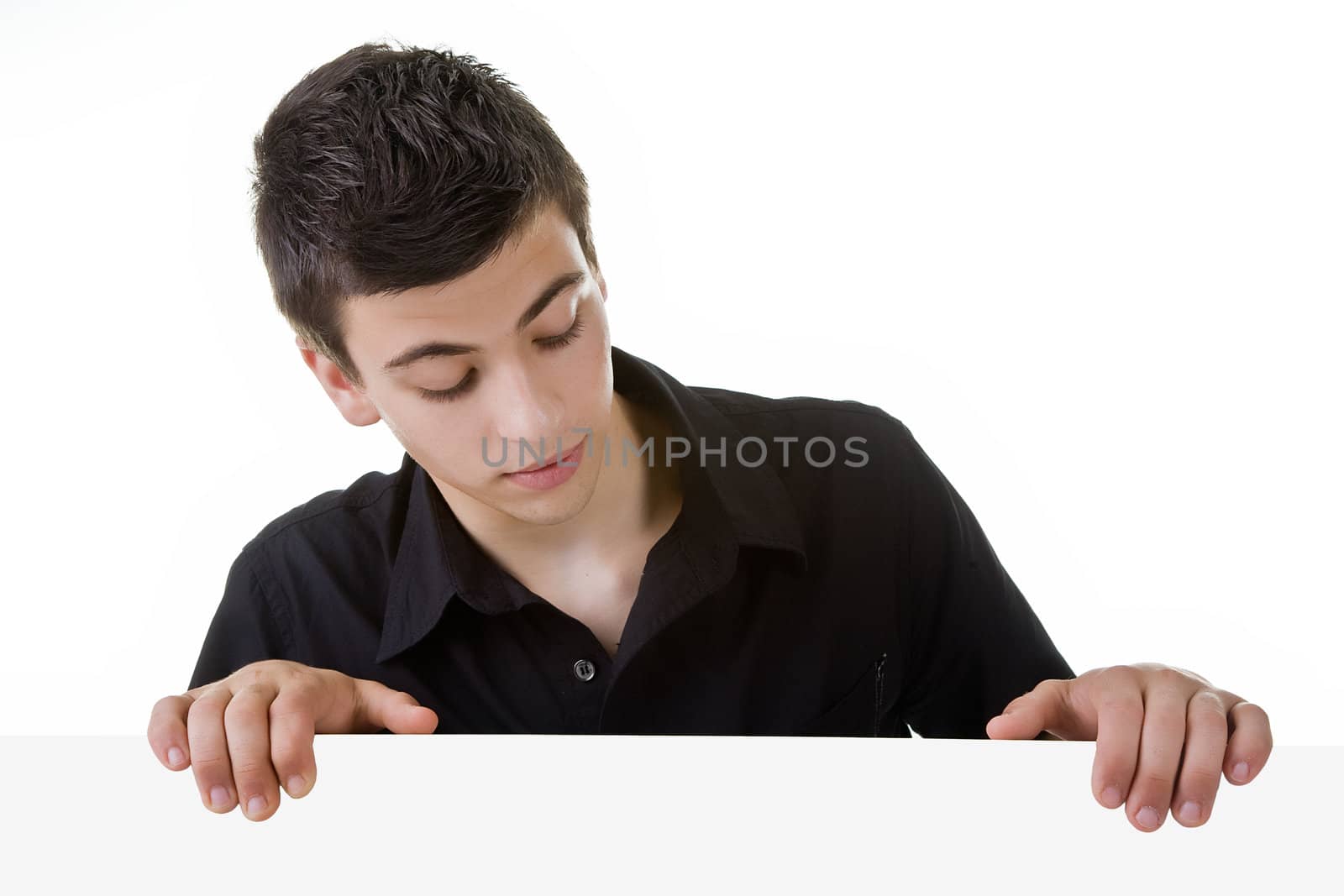 Young man, looking down to a blank board, with curious expression.