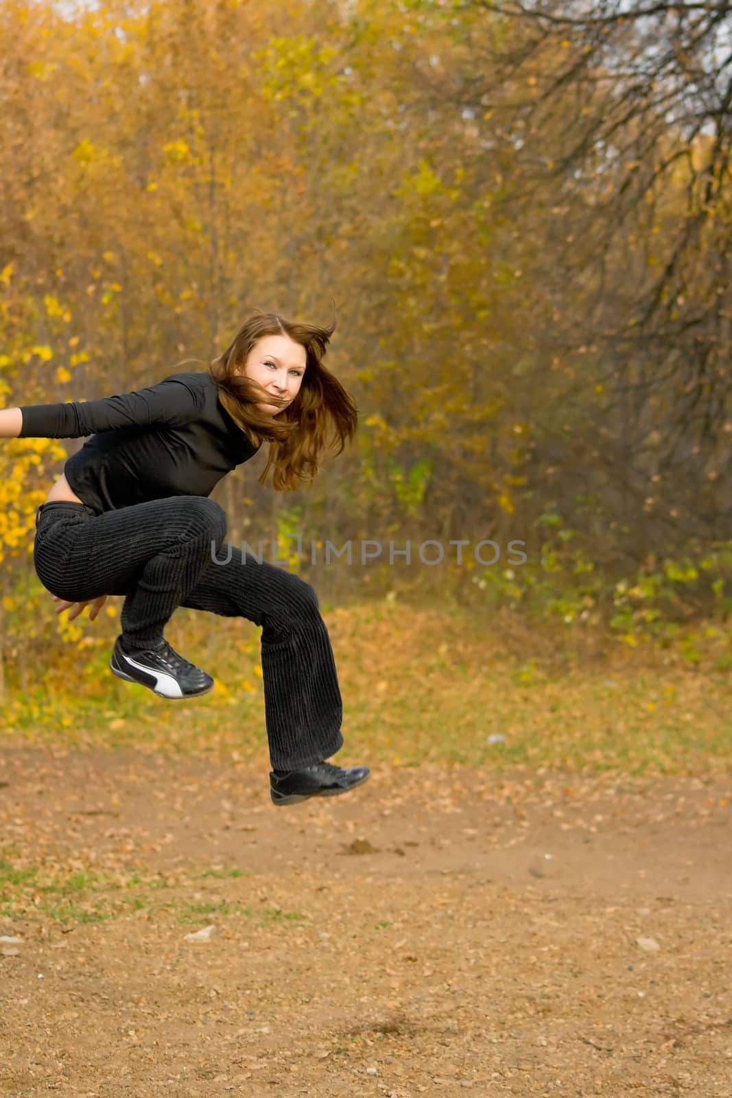 The jumping girl against the autumn nature