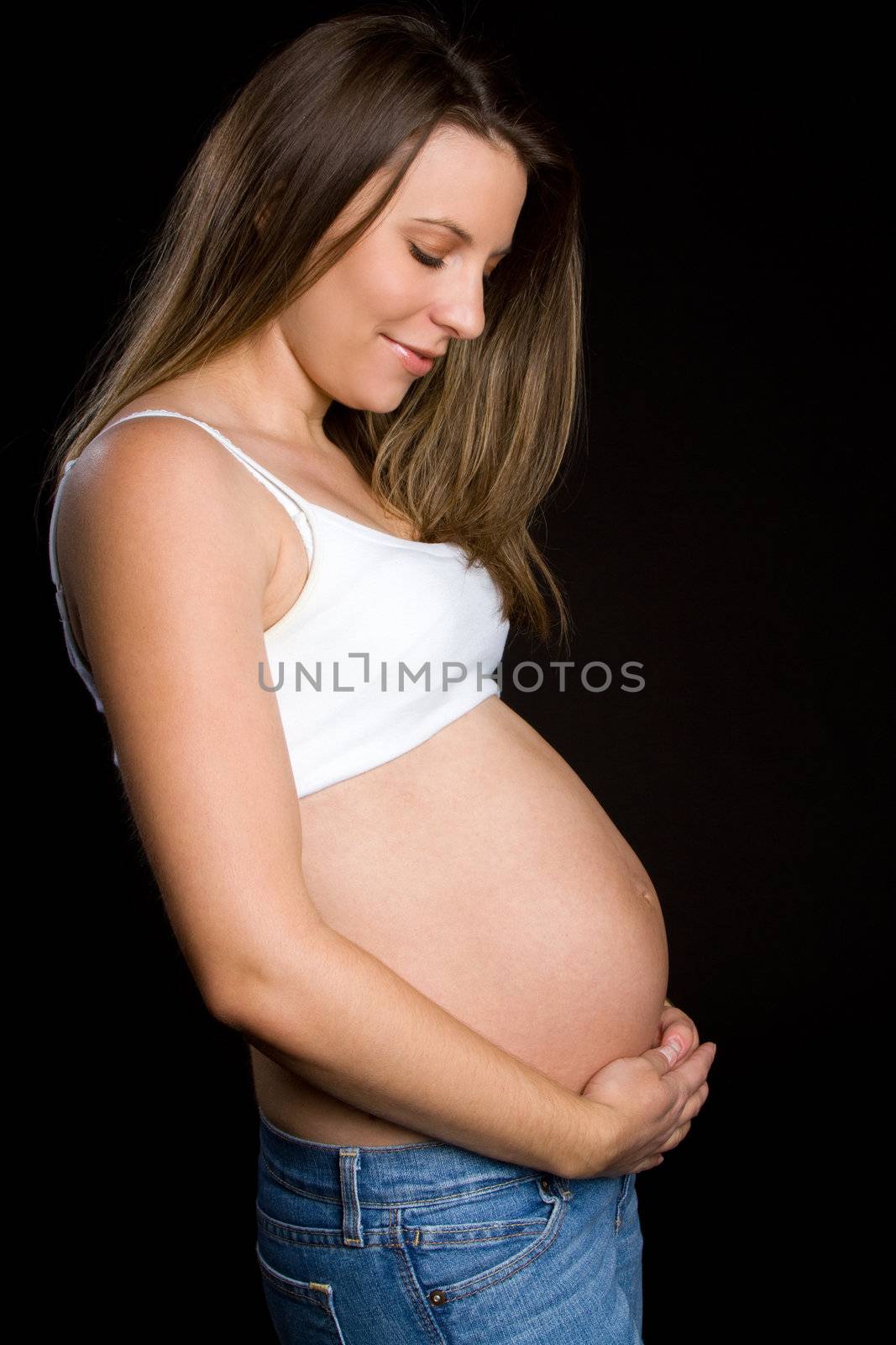 Beautiful young pregnant woman holding belly