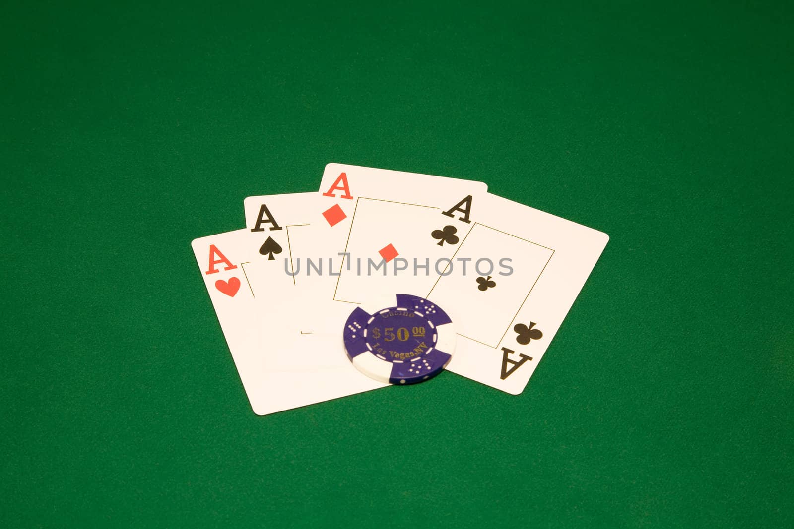 Four aces on the green table in casino with chips