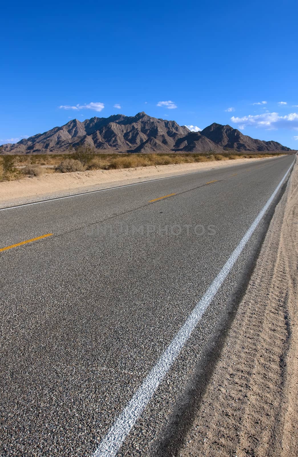 Old asphalt road in the California with blue sky