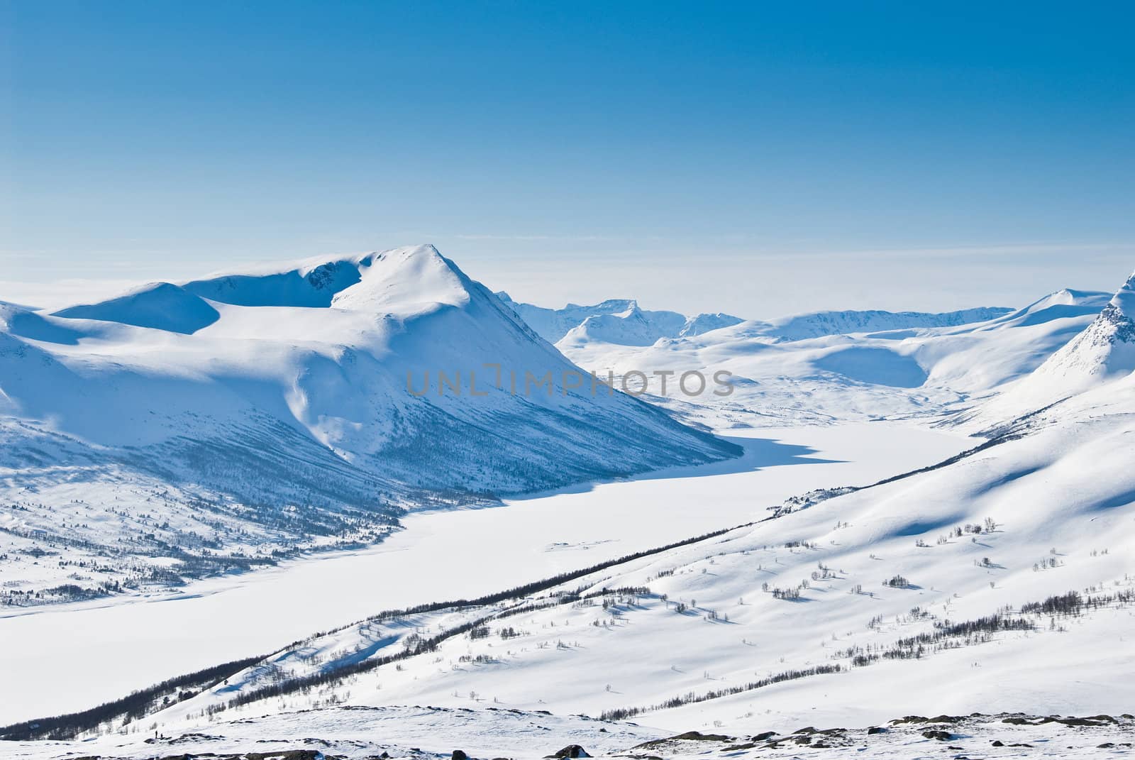 A snowy mountain landscape on a beautiful winter day. Picture taken in Oppdal, Norway, looking over Gjevillvatnet.