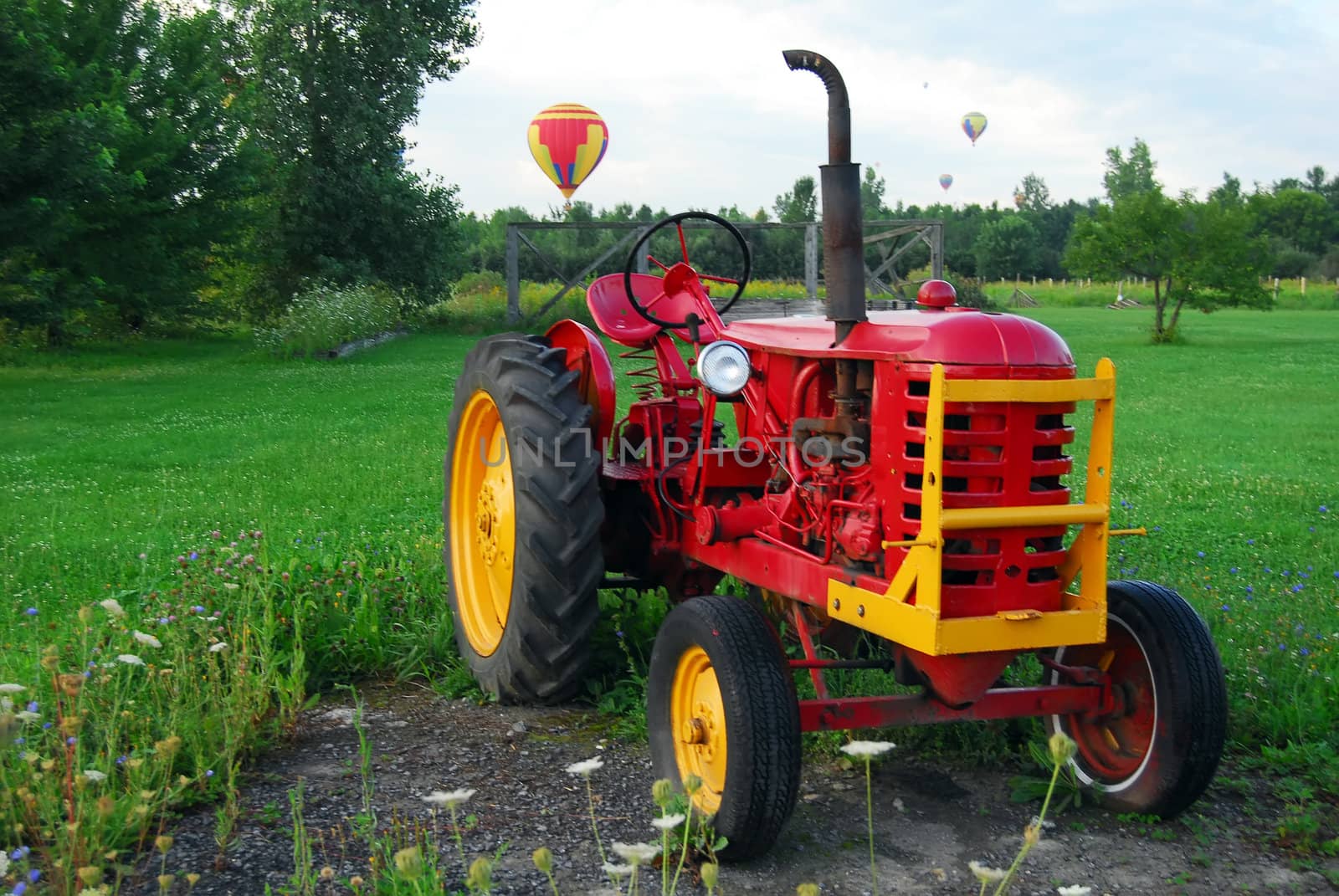 Hot Air Balloons over a field and an old tractor