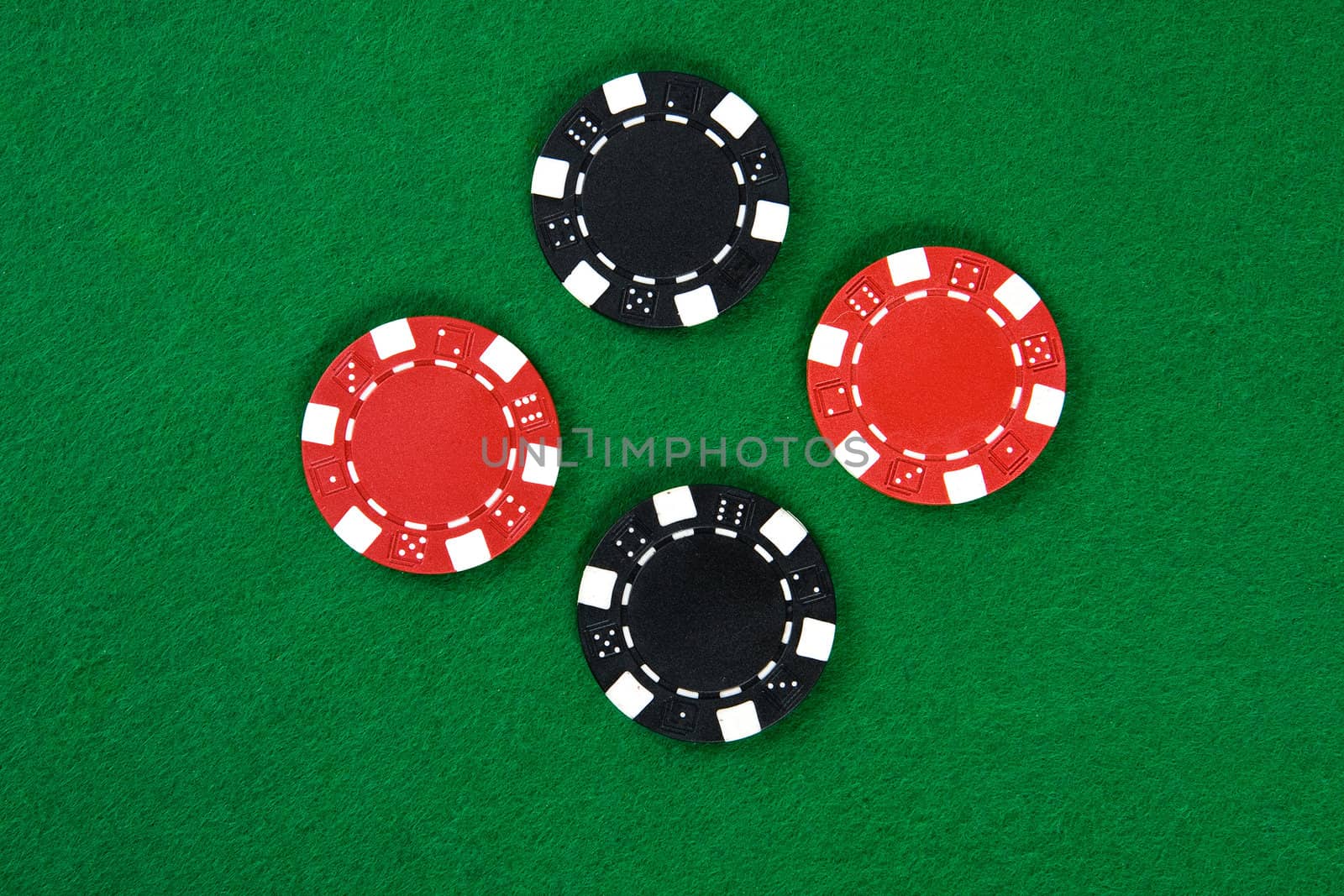 Two kinds of poker chips in the middle of green poker table. Top view.