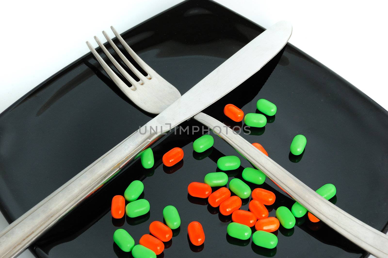 chemical diet - colored pills on black japanise plate