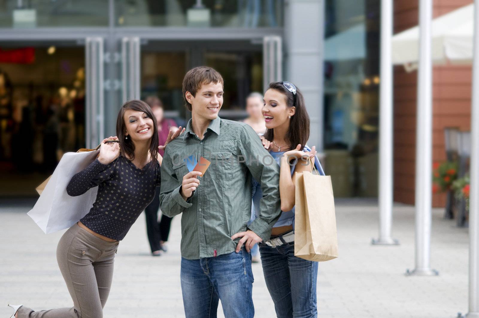 two girls happy and one men playing with them with credit cards