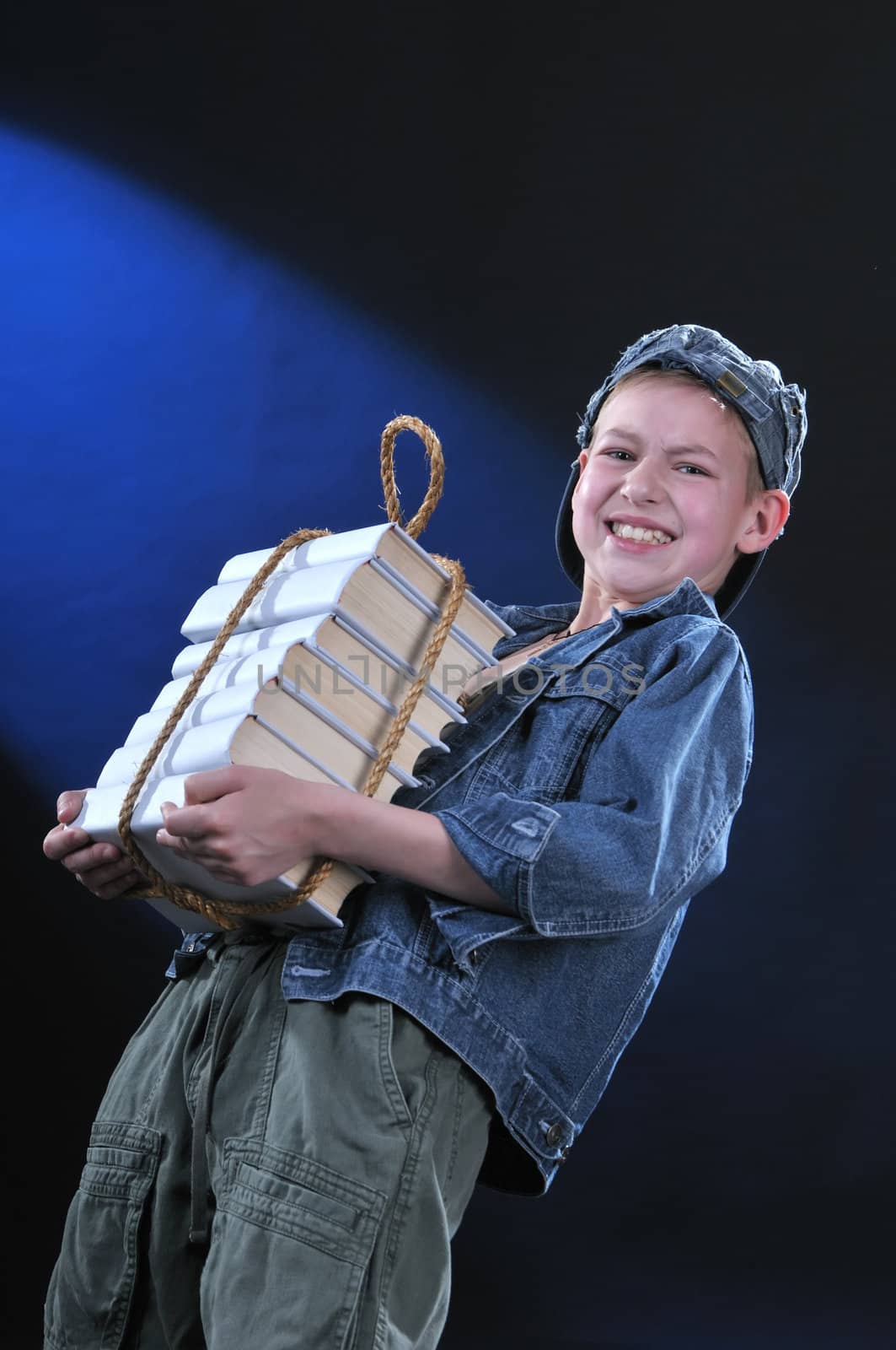 boy of ten years gets on the hip an exhausting load from the pile of books