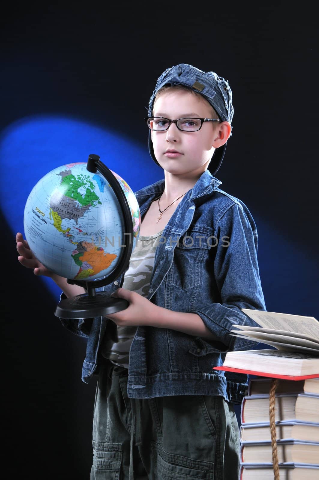 The boy of ten years in glasses gets on the hip student's globe. Low key