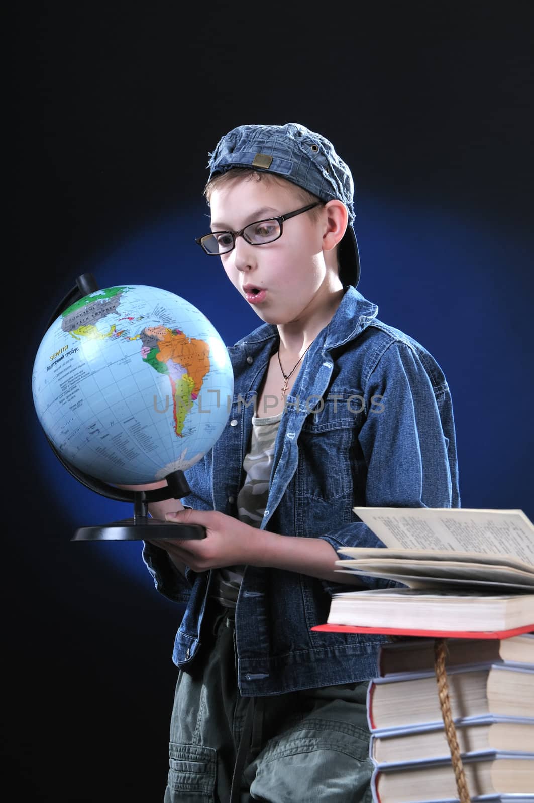 The boy of ten years in glasses gets on the hip student's globe