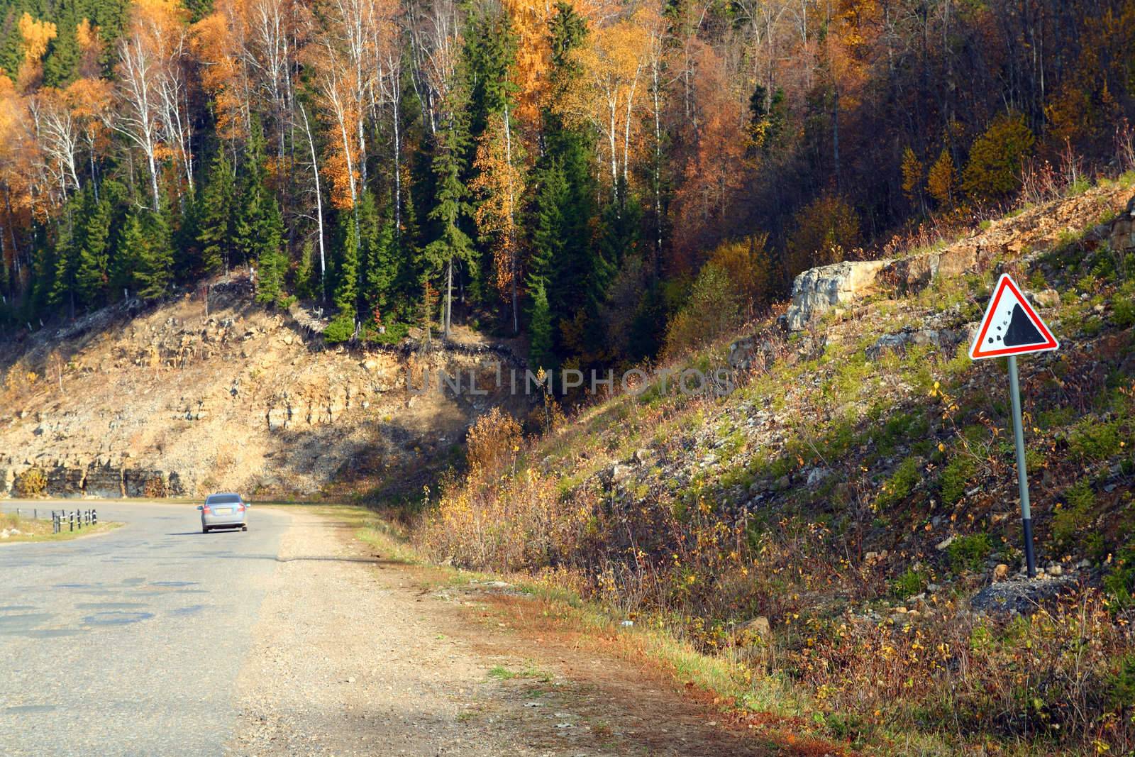 road with sign in mountains by Mikko