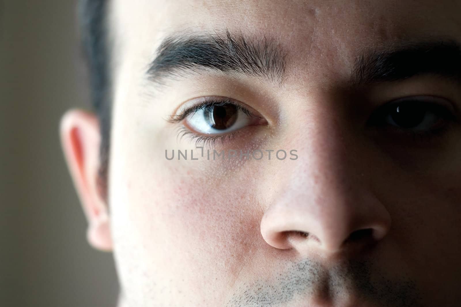 A closeup of the eye on a young man with a serious look on his face