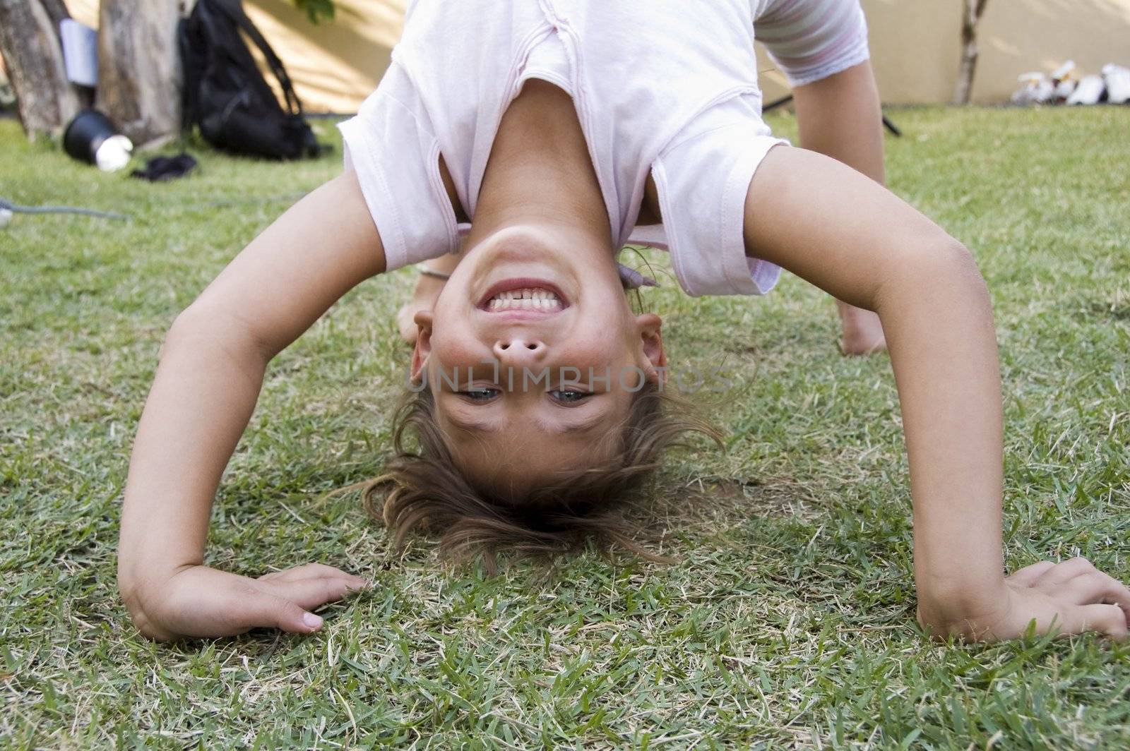 cute girl doing a bridge in the garden