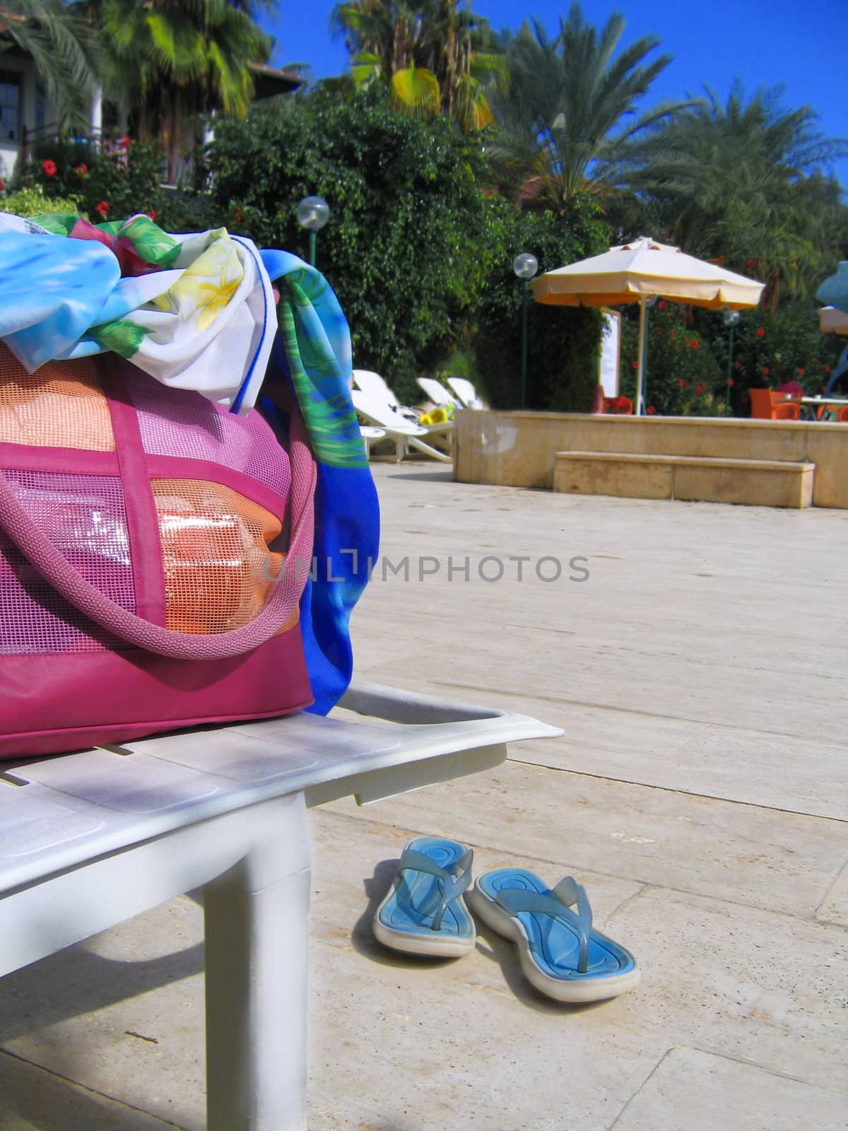 beach wear, bag and sandals near swimming pool 