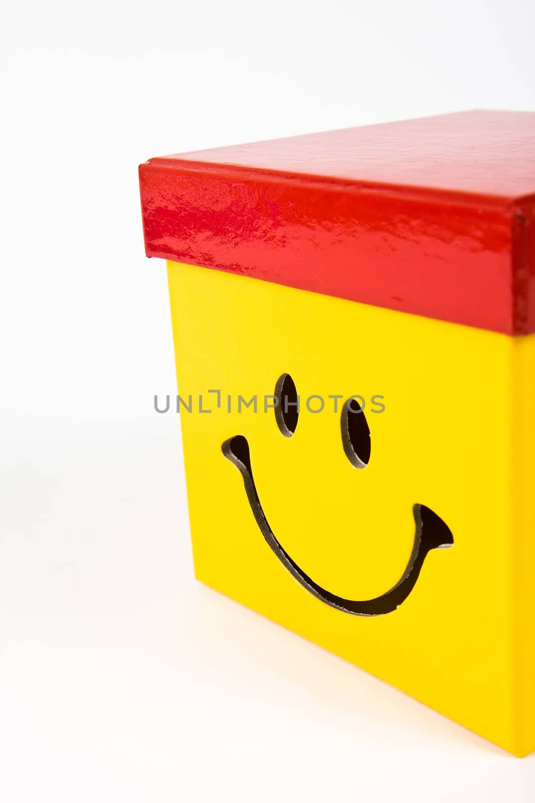 Smile on a yellow gift box with red cap.