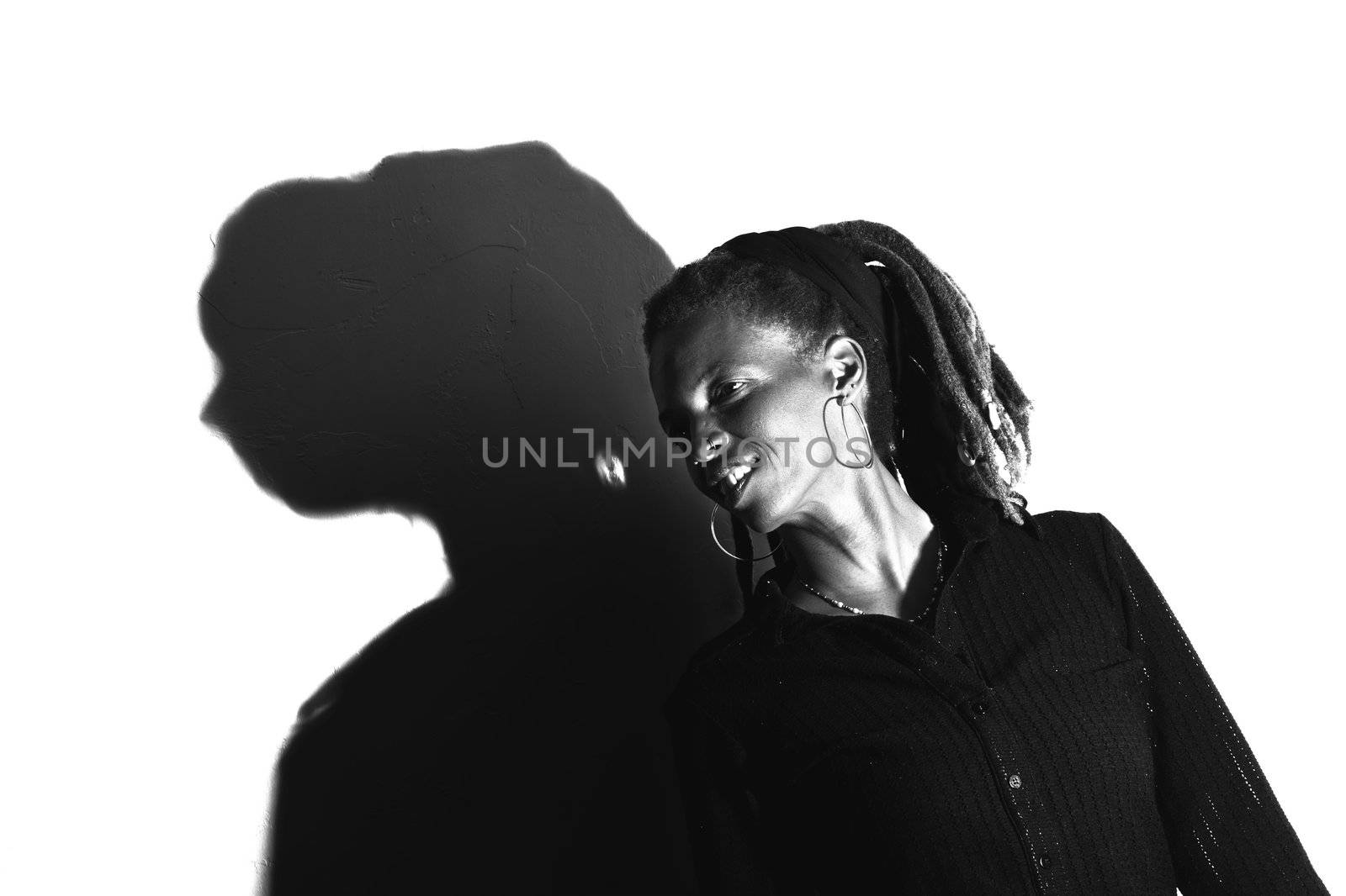 African American woman with dreadlocks against a white wall