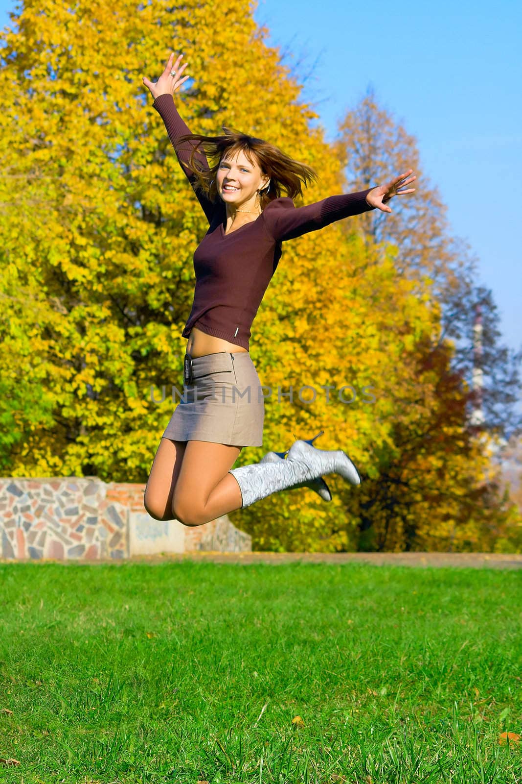 The jumping girl against the autumn nature