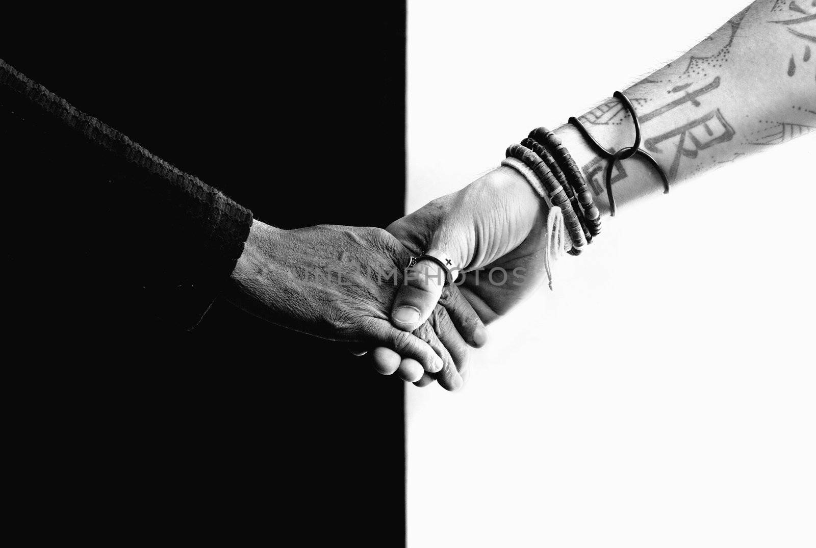 Close up of black and white hands holding each other