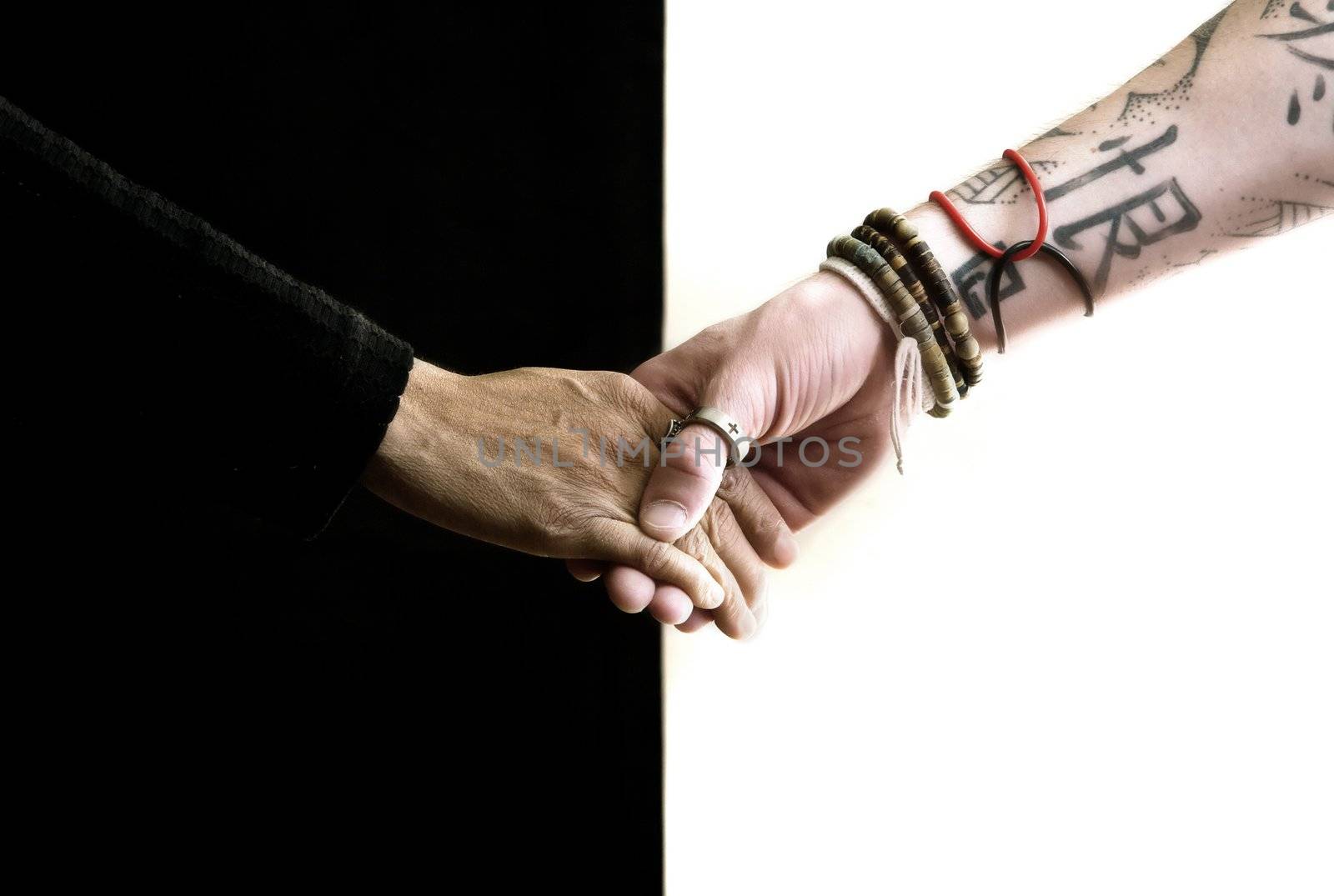 Close up of black and white hands holding each other