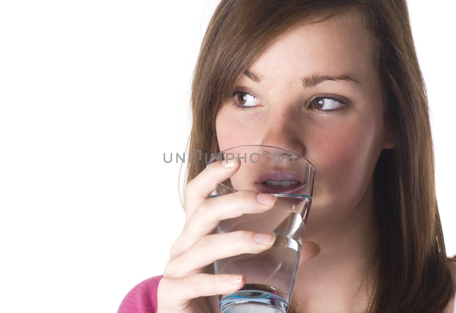 Beautiful teenage girl drinking glass of water; isolated on white.