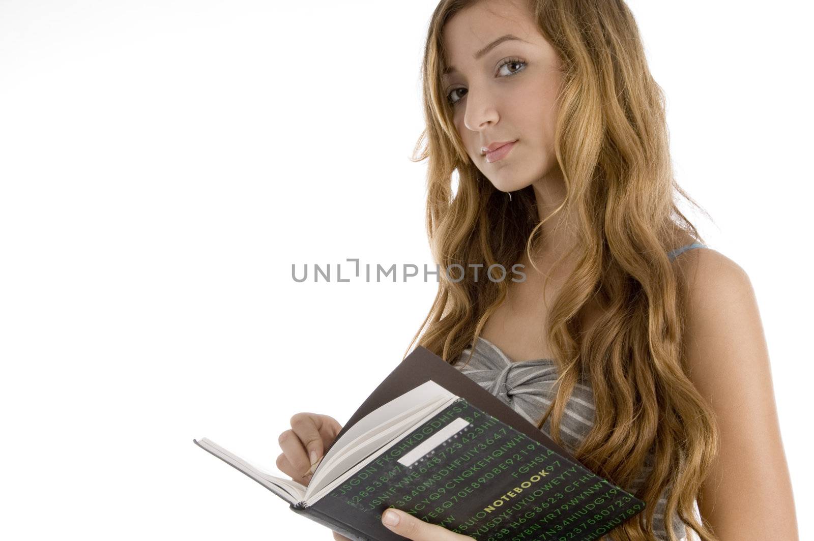 school girl looking at  camera with open book on  an isolated white background 