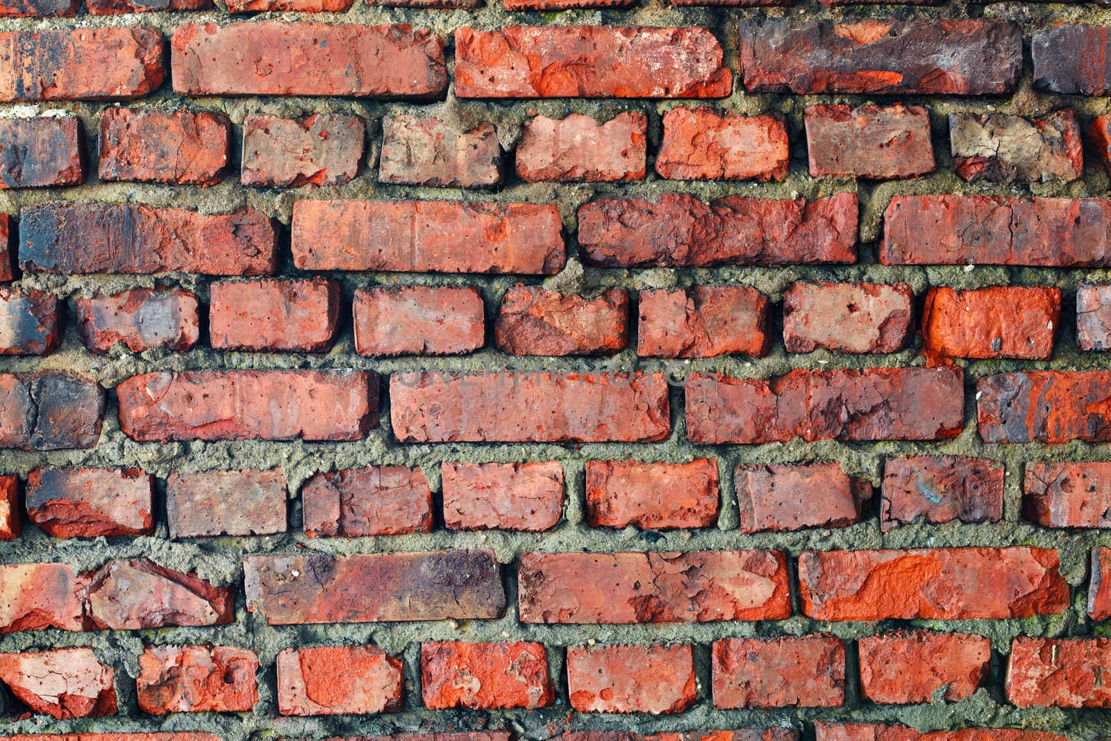 Red rough old dilapidated brick wall - background
