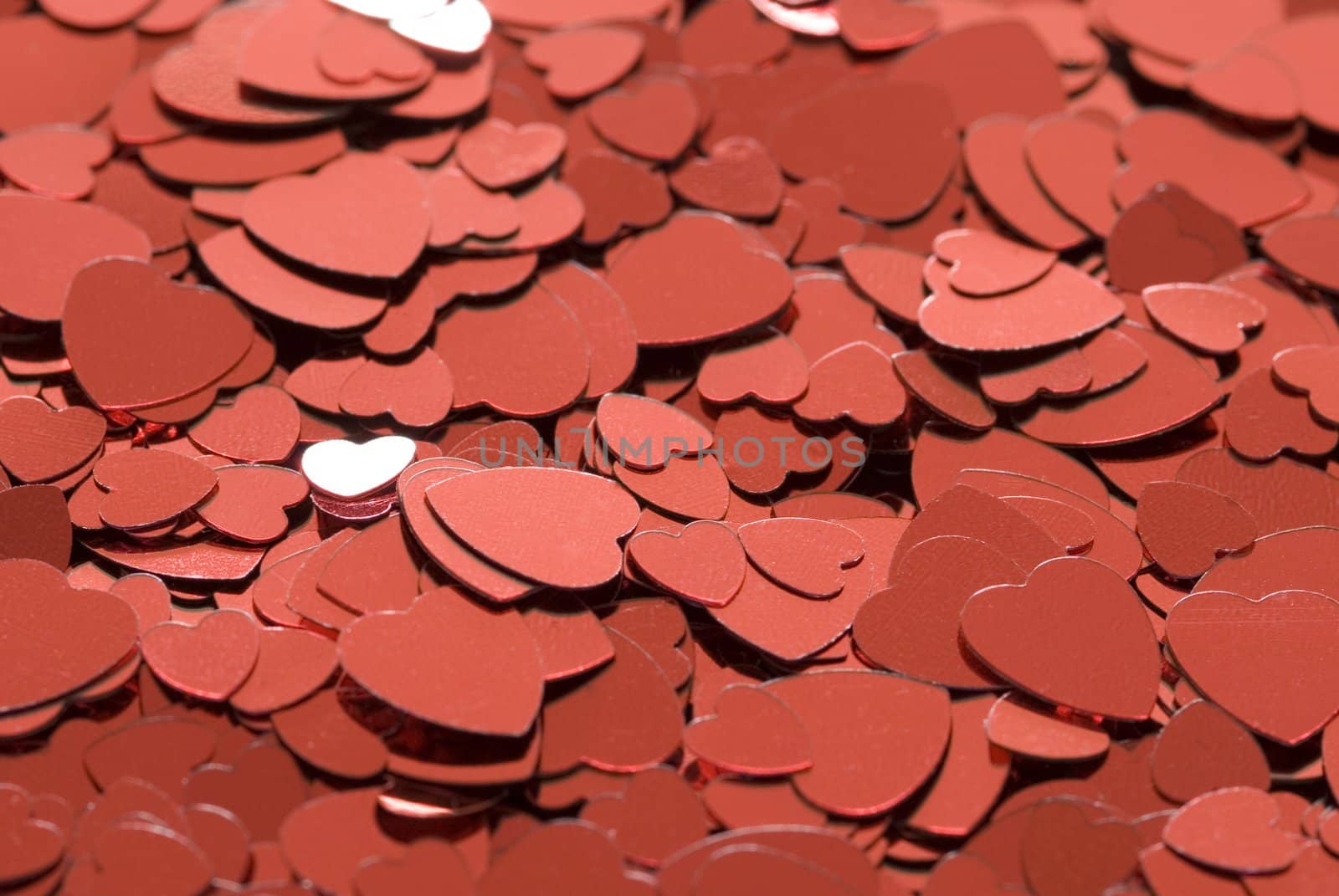 a background of red metallic love heart shaped confetti