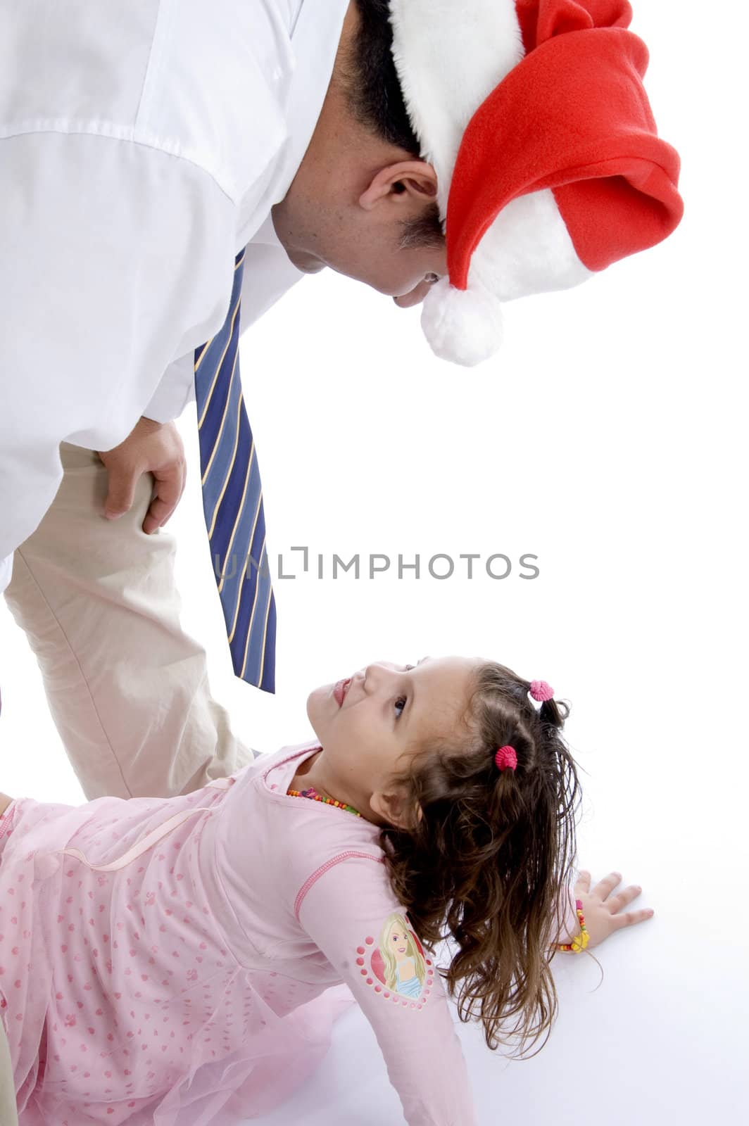 father wearing christmas hat playing with his little daughter