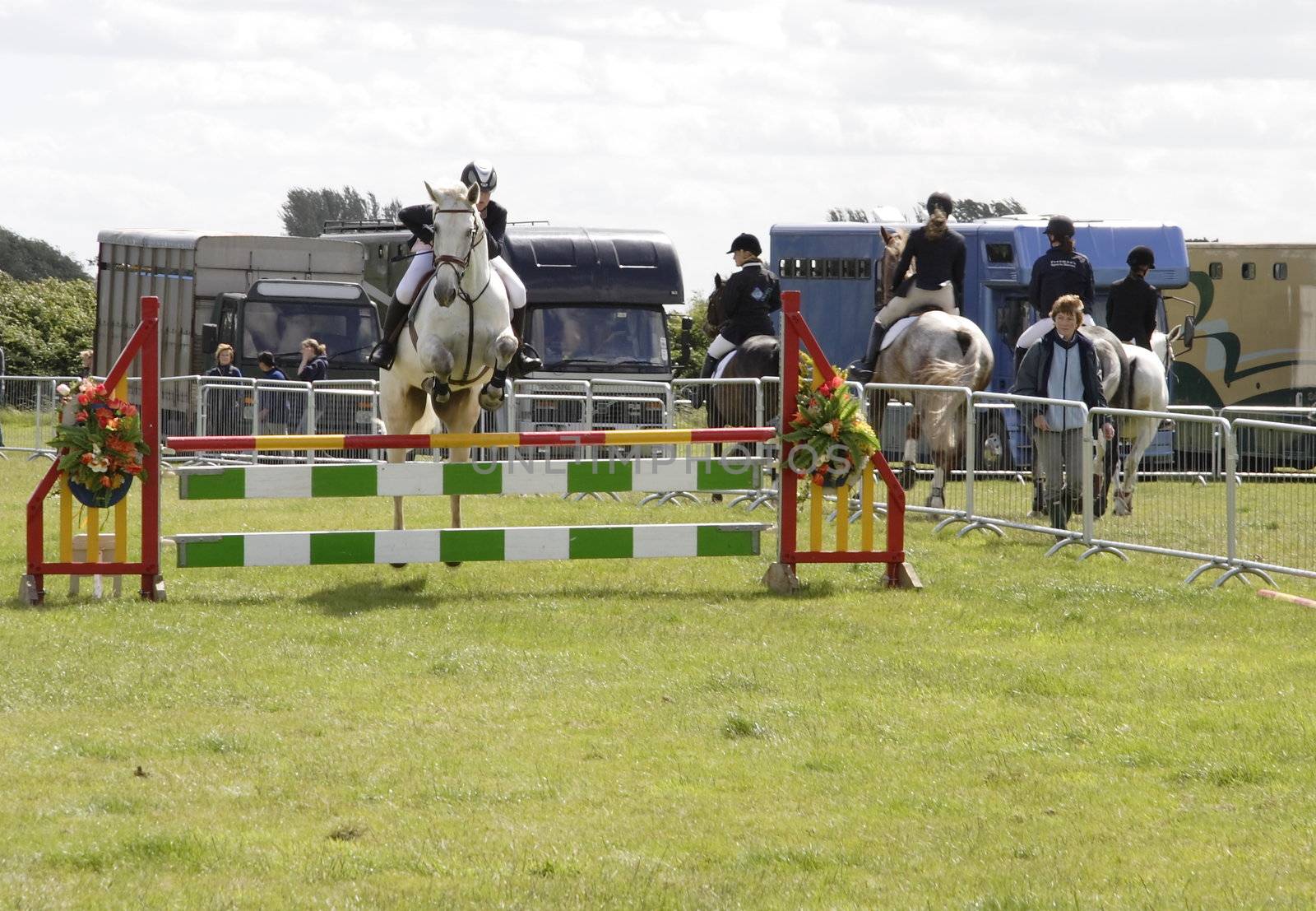 horses jumping fences at a show jumping competion