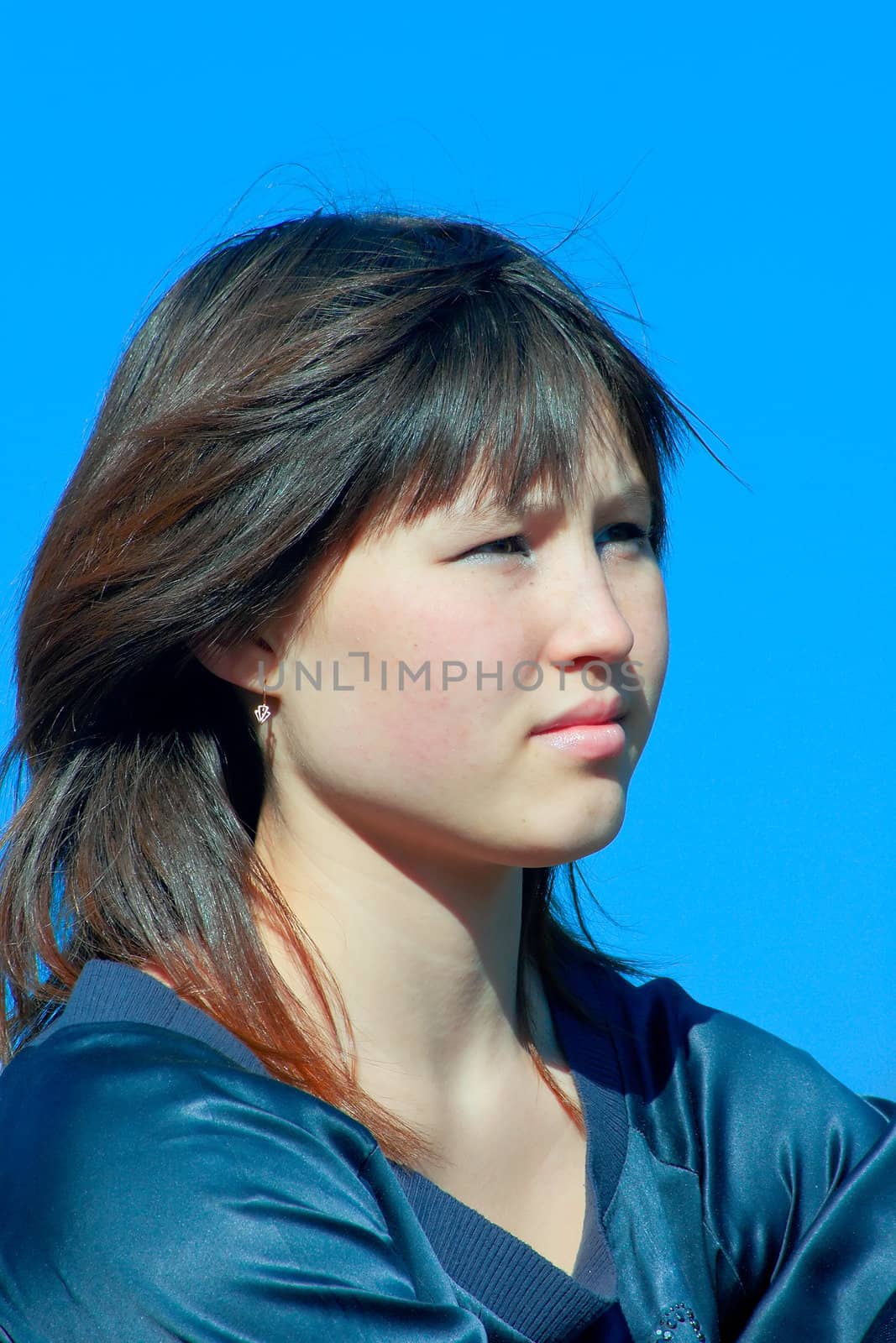 Portrait of the beautiful asian girl against blue sky