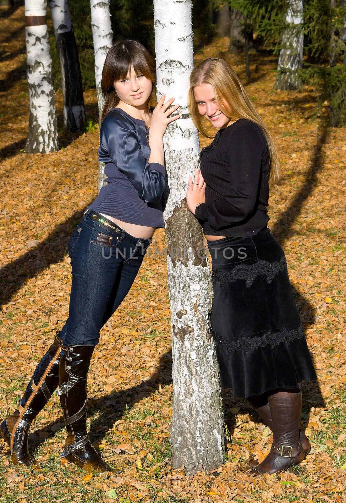Two girlfriends against the autumn nature