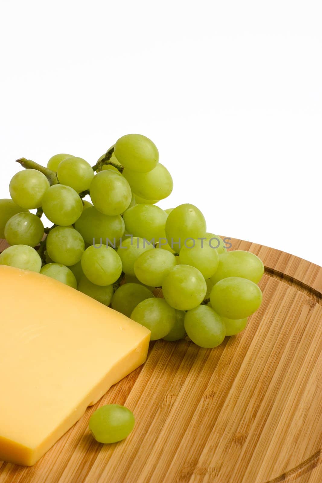 green grapes and cheese on a wooden board
