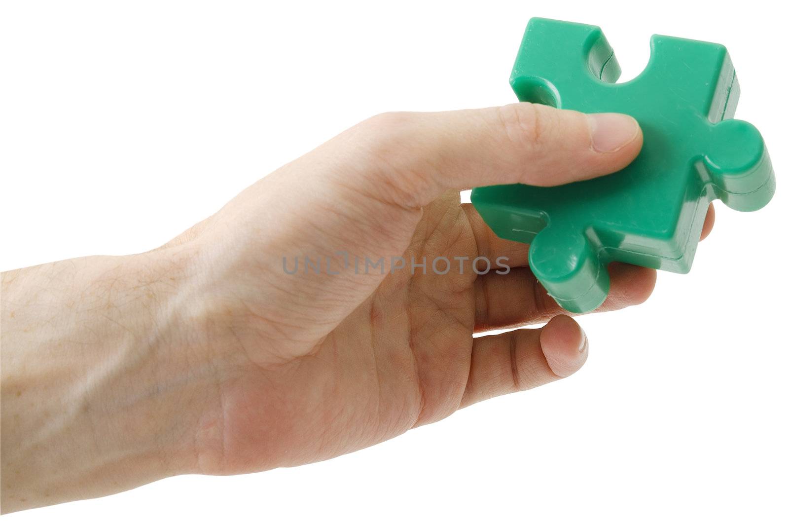 The hand holding a green piece puzzle on a white background