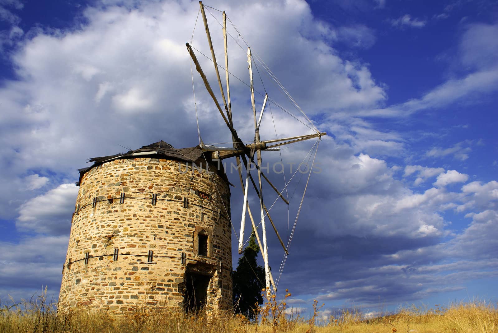 An old windmill in Ormylia (Halkidiki) on a cloudy day in July.