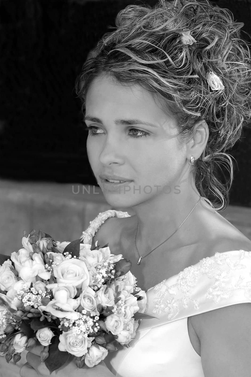 Black and white portrait of pretty young bride with bouquet of flowers.