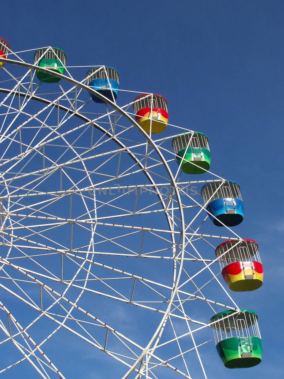 a colourful fairground wheel against a blue sky