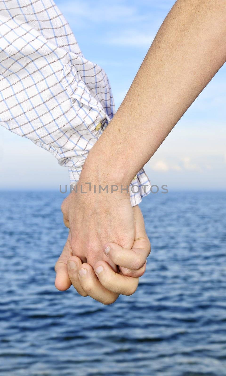 Mature romantic couple holding hands on the beach