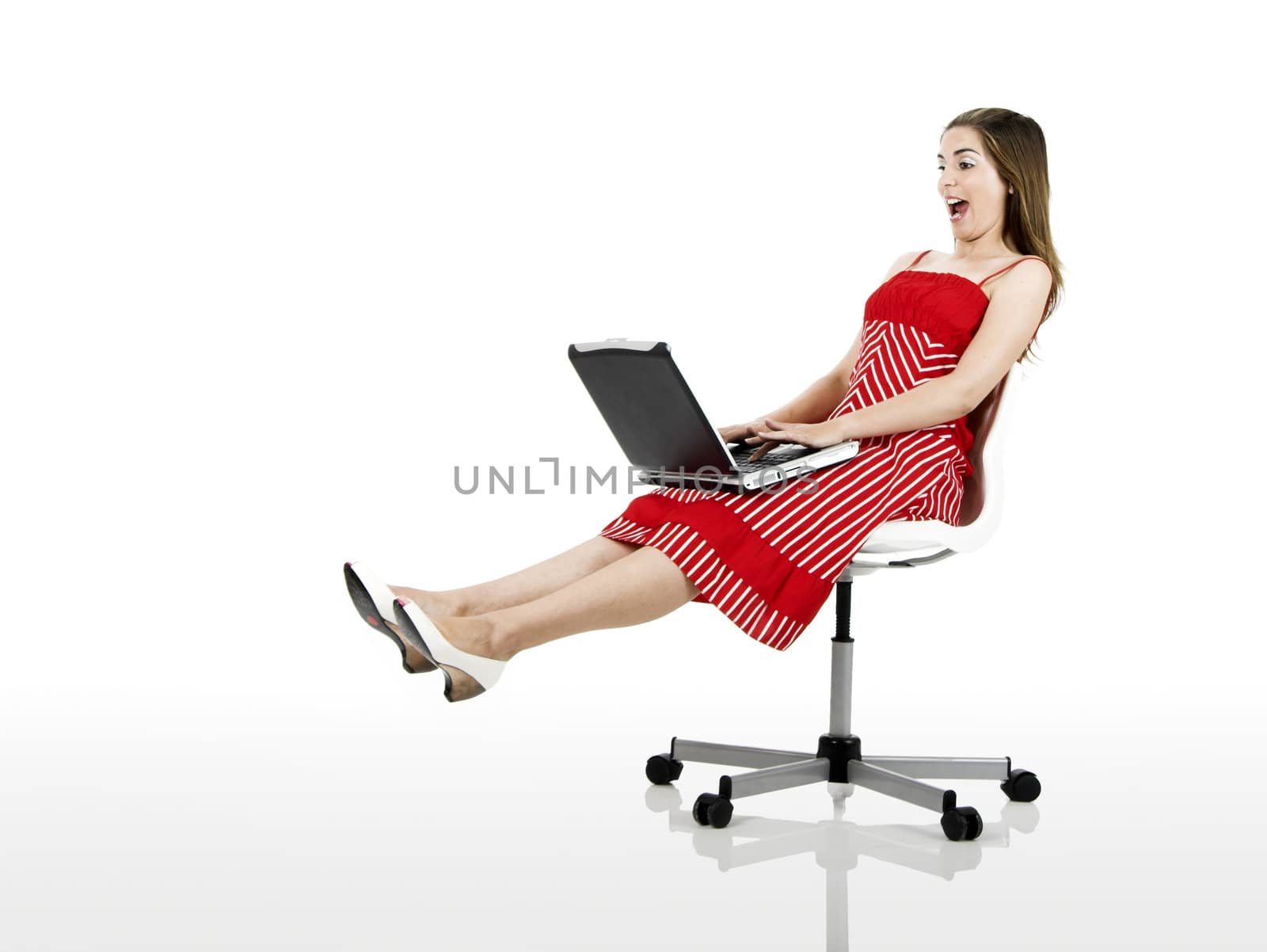 Portrait of a happy woman seated on a chair with a laptop - isolated on white