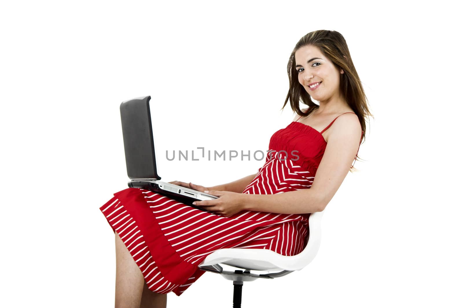Portrait of a young beautiful woman seated on a chair with a laptop - isolated on white