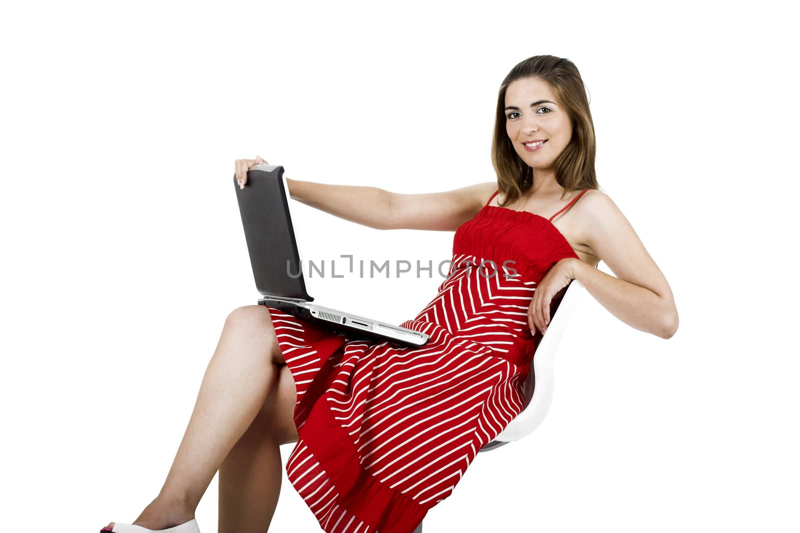 Portrait of a young beautiful woman seated on a chair with a laptop - isolated on white