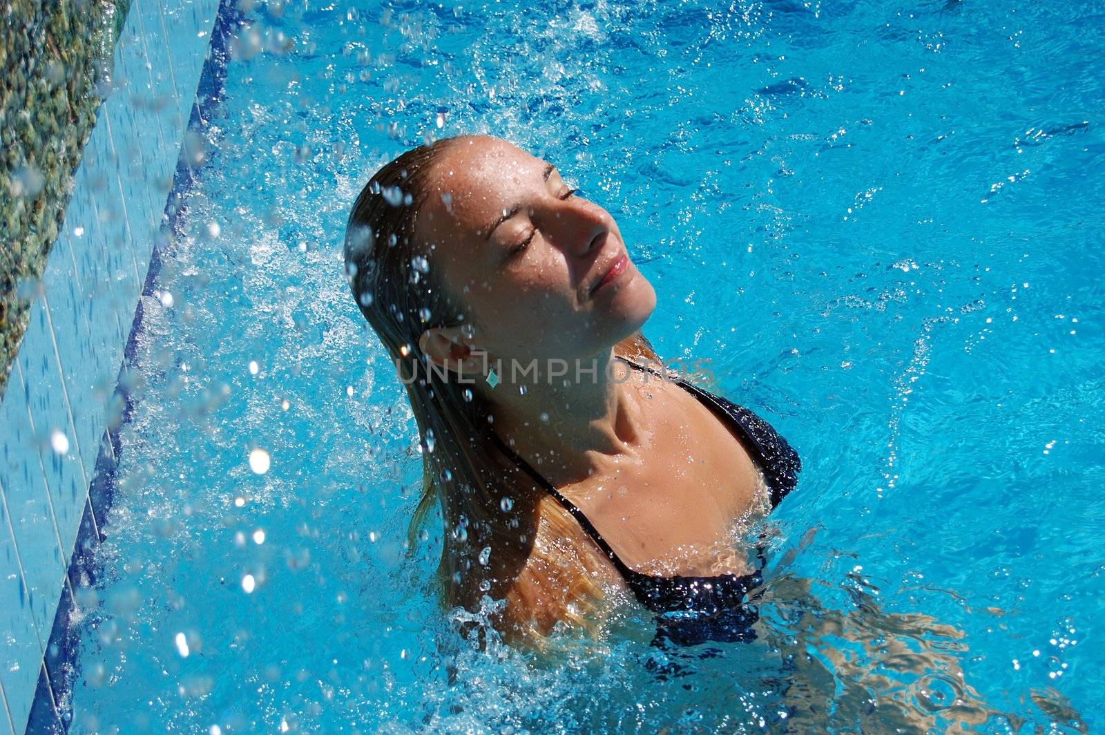 beautiful woman in pool under water drops