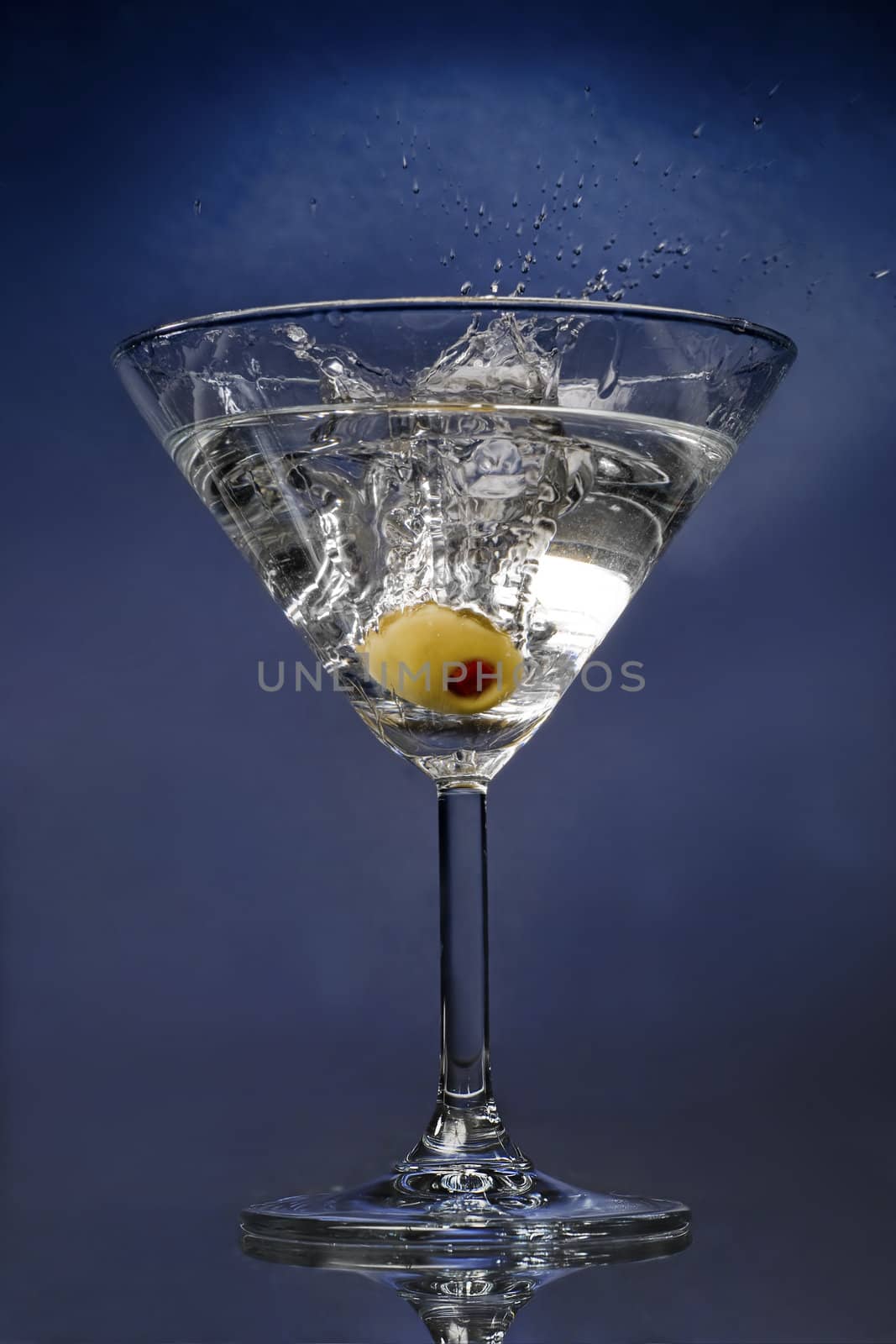 Ready cocktail with an olive splashing