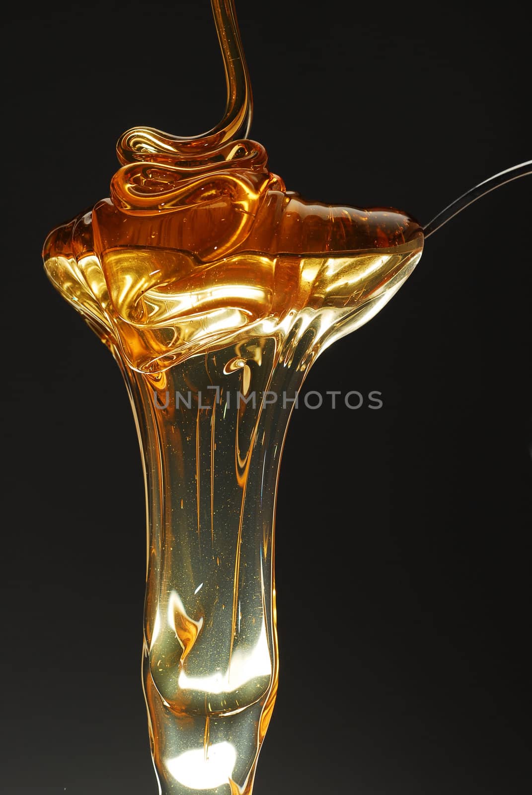 Gold honey spilling stock photo