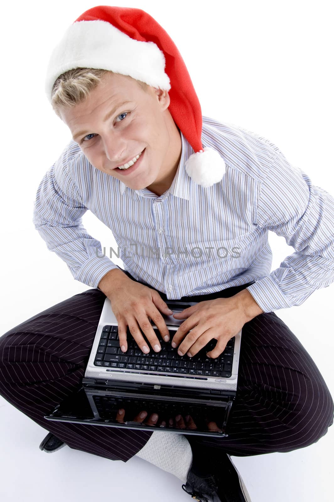 male working on laptop and looking to camera against white background