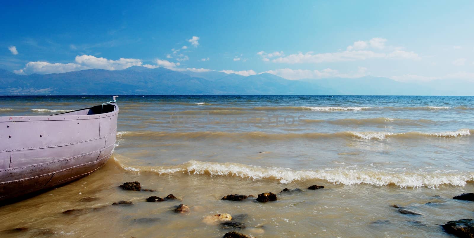 boat on beach of lake prespa, troubled water