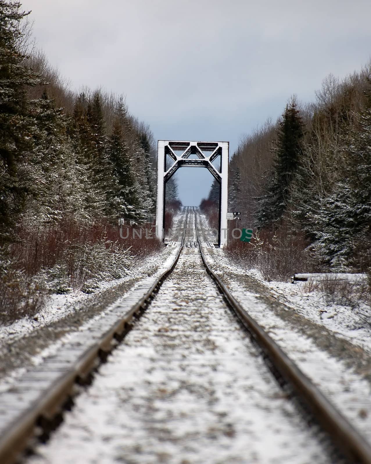 Picture of a railroad with a bidge in the distance