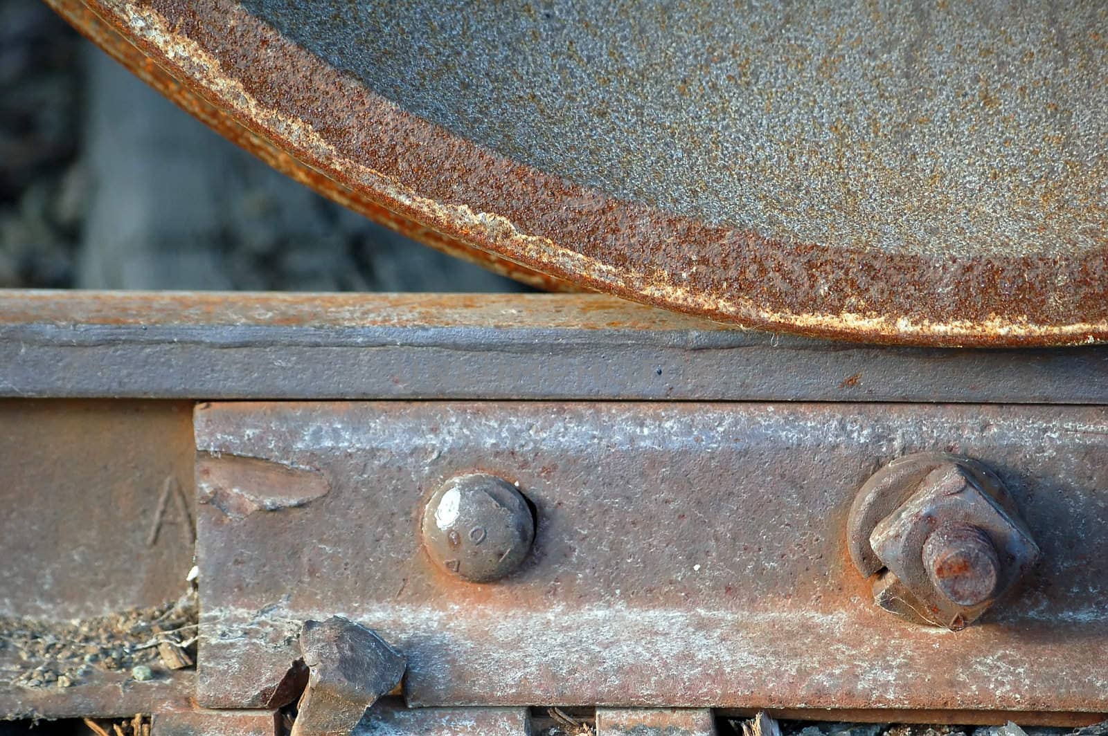Close-up of a rusted  train's wheel on a rail