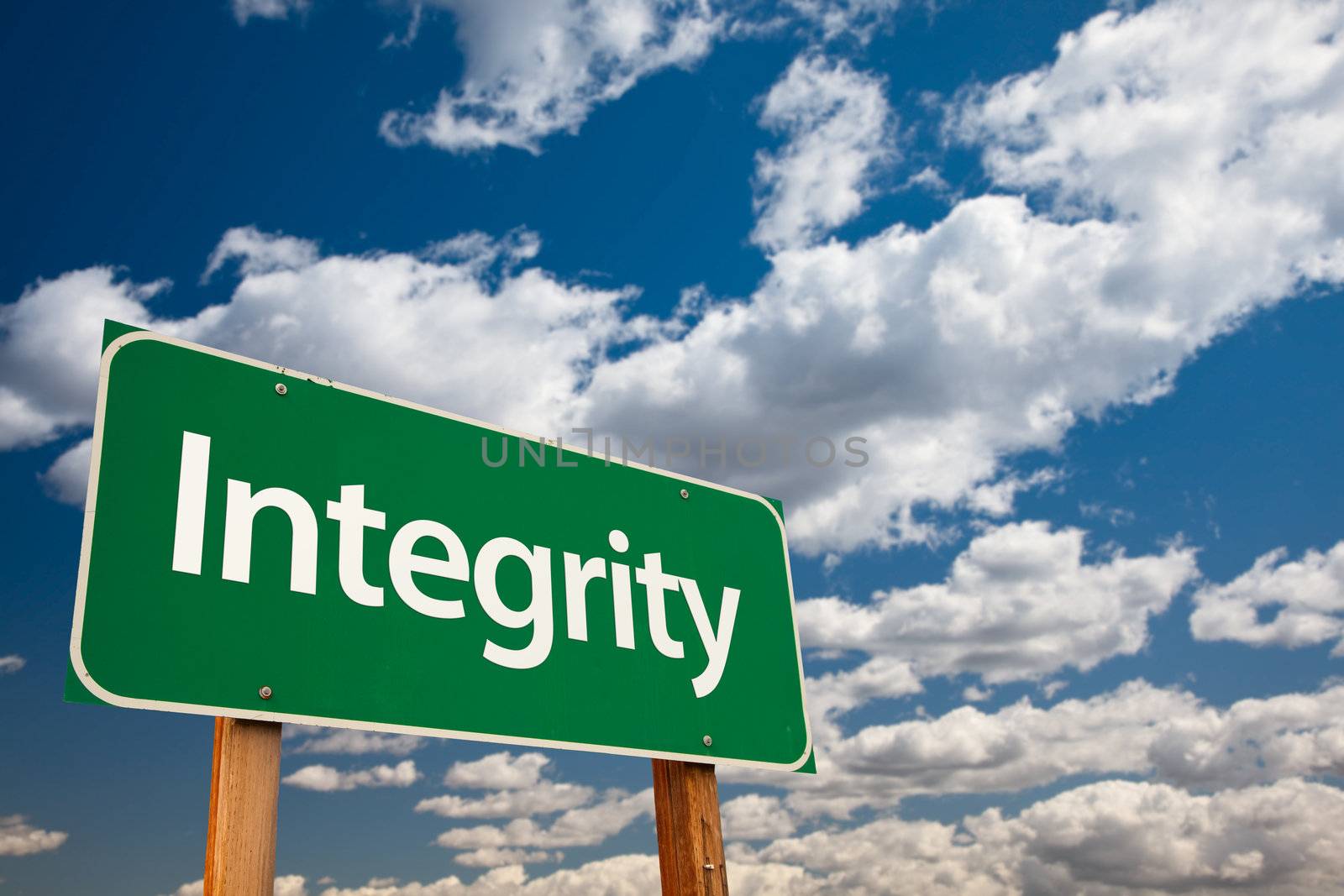 Integrity Green Road Sign with Copy Room Over The Dramatic Clouds and Sky.