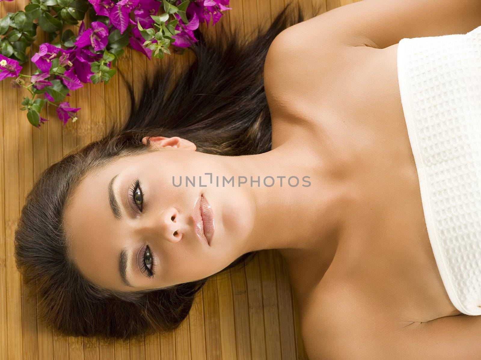 portrait of a beautiful brunette laying down on a wood carpet