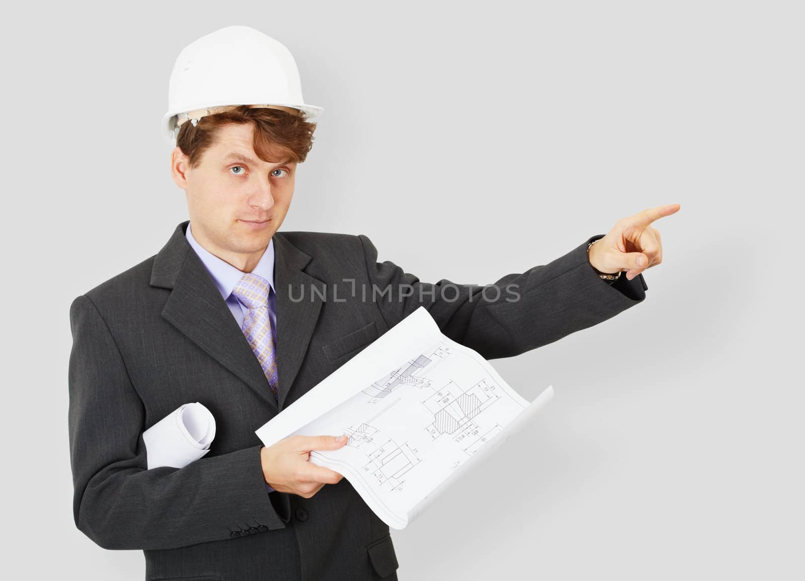 The young engineer a building specialist in a helmet with the drawing in a hand